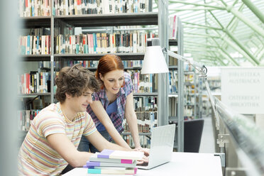 Zwei Studenten in einer Universitätsbibliothek mit Laptop - WESTF019716