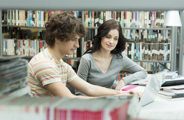 Zwei Studenten in einer Universitätsbibliothek mit Laptop - WESTF019724