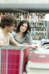 Zwei Studenten in einer Universitätsbibliothek mit Laptop - WESTF019725