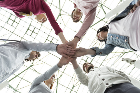 Gruppe junger Menschen, die ihre Hände stapeln, lizenzfreies Stockfoto