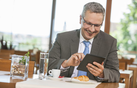 Geschäftsmann im Restaurant mit digitalem Tablet, lizenzfreies Stockfoto