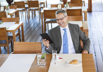 Geschäftsmann im Restaurant mit digitalem Tablet - DISF000847