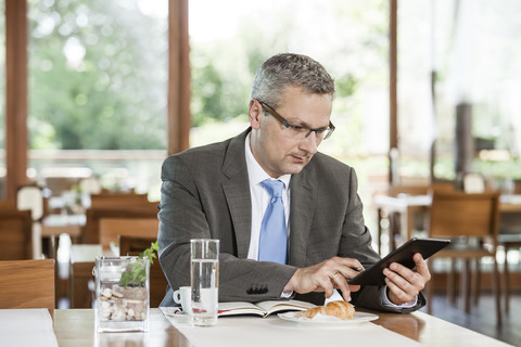 Geschäftsmann im Restaurant mit digitalem Tablet, lizenzfreies Stockfoto
