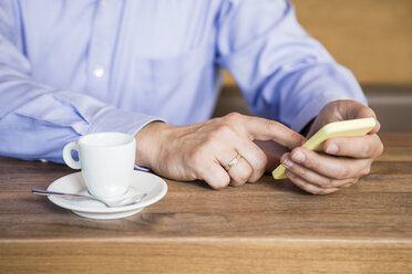 Businessman in cafe using cell phone, close-up - DISF000868