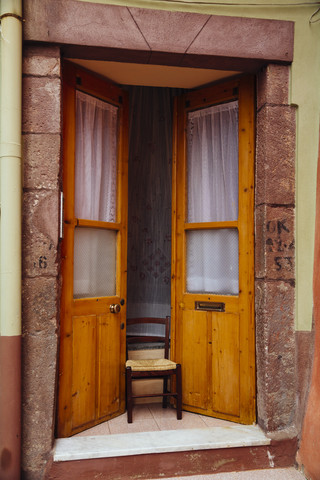 Italien, Sarinia, Bosa, Alte Tür, Schranke mit Stuhl, lizenzfreies Stockfoto