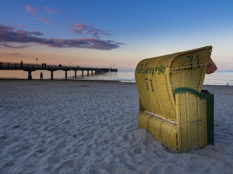 Deutschland, Schleswig-Holstein, Scharbeutz, Seebrücke, Überdachter Strandkorb am Strand am Abend - AMF002466