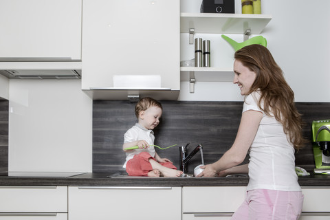 Mutter mit kleinem Jungen in der Küche, lizenzfreies Stockfoto