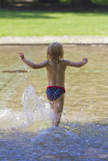 Little girl running into a pond - JFEF000415