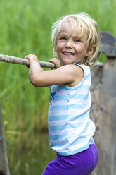 Little girl balancing on a wooden raft - JFEF000458