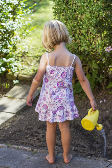 Little girl pouring with little water can - JFEF000445