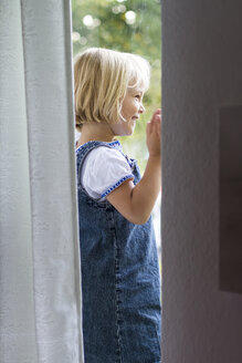 Porträt eines kleinen Mädchens, das am Fenster steht - JFEF000450
