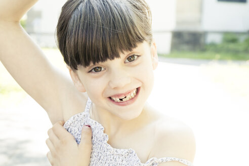 Porträt eines lächelnden kleinen Mädchens mit Zahnlücke, das ein Gesicht macht - LVF001505