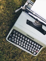 Tragbare mechanische Schreibmaschine im Freien auf einer Wiese, - HAWF000348
