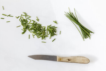 Chopped and whole chives and kitchen knife on white ground - EVGF000662