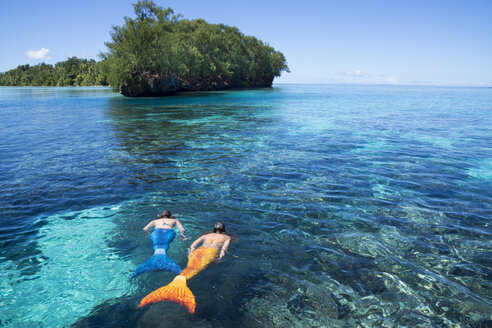 Palau, zwei junge Frauen im Meerjungfrauenkostüm schwimmen in einer Lagune - JWAF000104