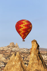Turkey, Cappadocia, hot air balloon hoovering in front of the village Uchisar at Goereme National Park - SIEF005524