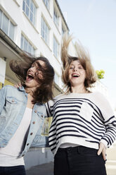 Two happy young women jumping outdoors - STKF000907