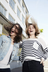 Zwei glückliche junge Frauen springen im Freien - STKF000907