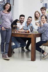 Gruppe von Kreativschaffenden mit Hund am Tisch - STKF001012