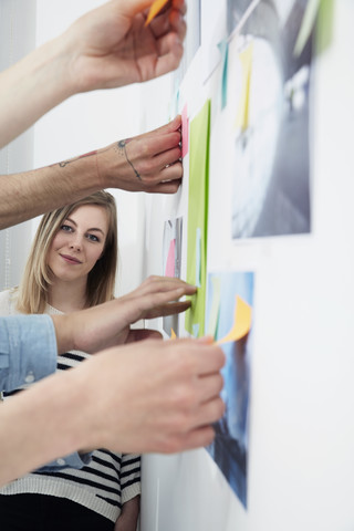 Frau lehnt mit Haftnotizen an der Wand, lizenzfreies Stockfoto