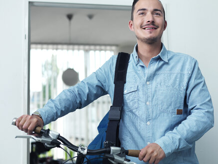 Mann schiebt Fahrrad im Büro - STKF001005