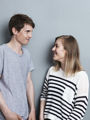 Porträt eines lächelnden Paares vor einem grauen Hintergrund - STKF000956