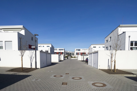 Deutschland, Hessen, Frankfurt Riedberg, Blick auf eine Wohnstraße mit Häusern und Garagen, lizenzfreies Stockfoto