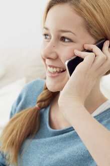 Porträt eines weiblichen Teenagers, der zu Hause mit seinem Smartphone telefoniert - STKF001018