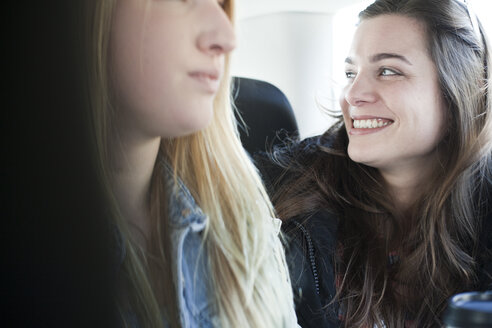 Two young women sitting on back seat of a car - FEXF000088