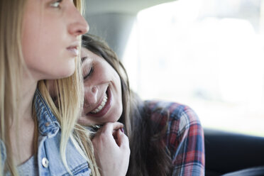 Zwei junge Frauen sitzen auf dem Rücksitz eines Autos - FEXF000087