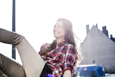 Laughing young woman having fun on a car roof - FEXF000084