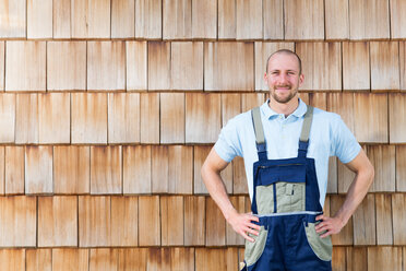 Selbstbewusster Handwerker an der Holzwand - FKCF000001