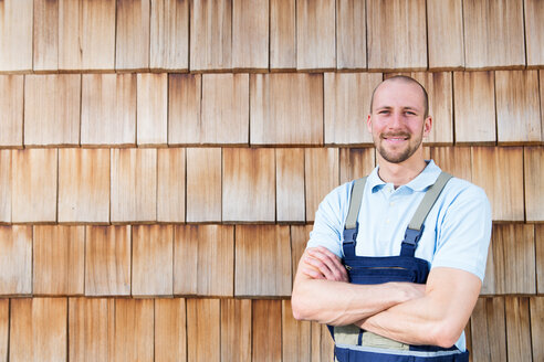 Selbstbewusster Handwerker an der Holzwand - FKCF000002