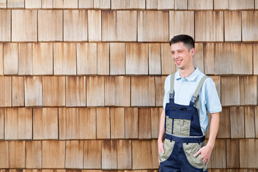 Selbstbewusster Handwerker an der Holzwand - FKCF000003