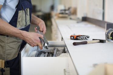 Handwerker hält ein Stück Metall - FKCF000059