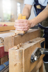 Schreiner hobelt Holz in der Werkstatt - FKCF000061