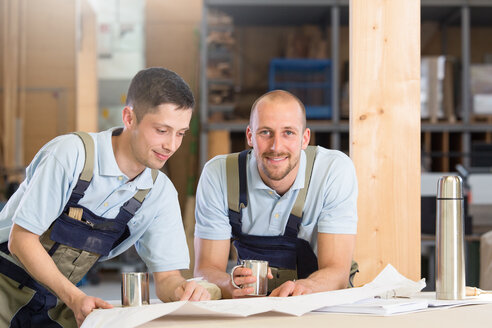 Two craftsmen with metal mugs talking - FKCF000025