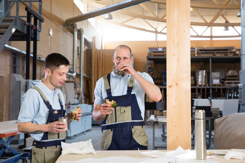 Handwerker in der Werkstatt bei der Frühstückspause, lizenzfreies Stockfoto