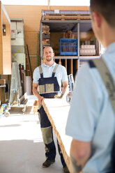 Two carpenters carrying wooden board - FKCF000056