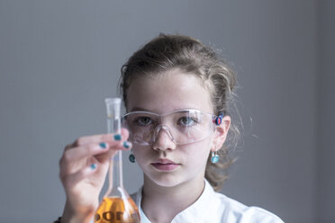 Female pupil holding glass with orange reagent - SGF000819