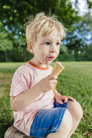 Deutschland, Nordrhein-Westfalen, Bonn, Blondes männliches Kleinkind isst Eiscreme, lizenzfreies Stockfoto