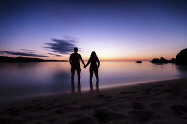 Spain, Menorca, Couple watching sunset at Playa de Cavalleria - SMAF000216