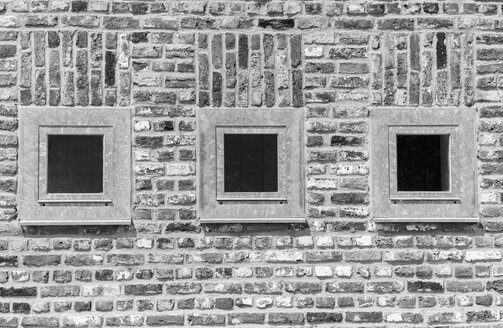 Deutschland, Nordrhein-Westfalen, Grevenbroich, Teil einer Backsteinfassade mit drei Fenstern - HLF000626