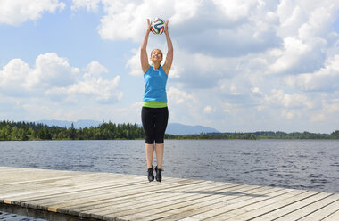 Germany, Bavaria, Sachsenkam, woman exercising functional training on jetty at sea - LHF000370