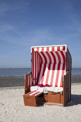 Deutschland, Niedersachsen, Dornum, Nessmersiel, rot-weißer Strandkorb mit Kapuze - WIF000875