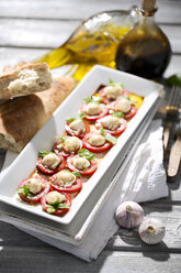 Mozzarellascheiben, Tomaten und Basilikumkraut auf weißem Teller - MAEF008678