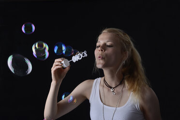 Young woman blowing soap bubbles - BFRF000472