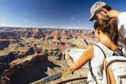 USA, Arizona, Paar mit Landkarte vor dem Grand Canyon orientierend, lizenzfreies Stockfoto