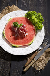 Wassermelone mit Schinken und Basilikum auf einem Teller - MAEF008686