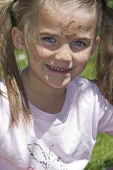Porträt eines lächelnden kleinen Mädchens mit Sand im Gesicht - YFF000196